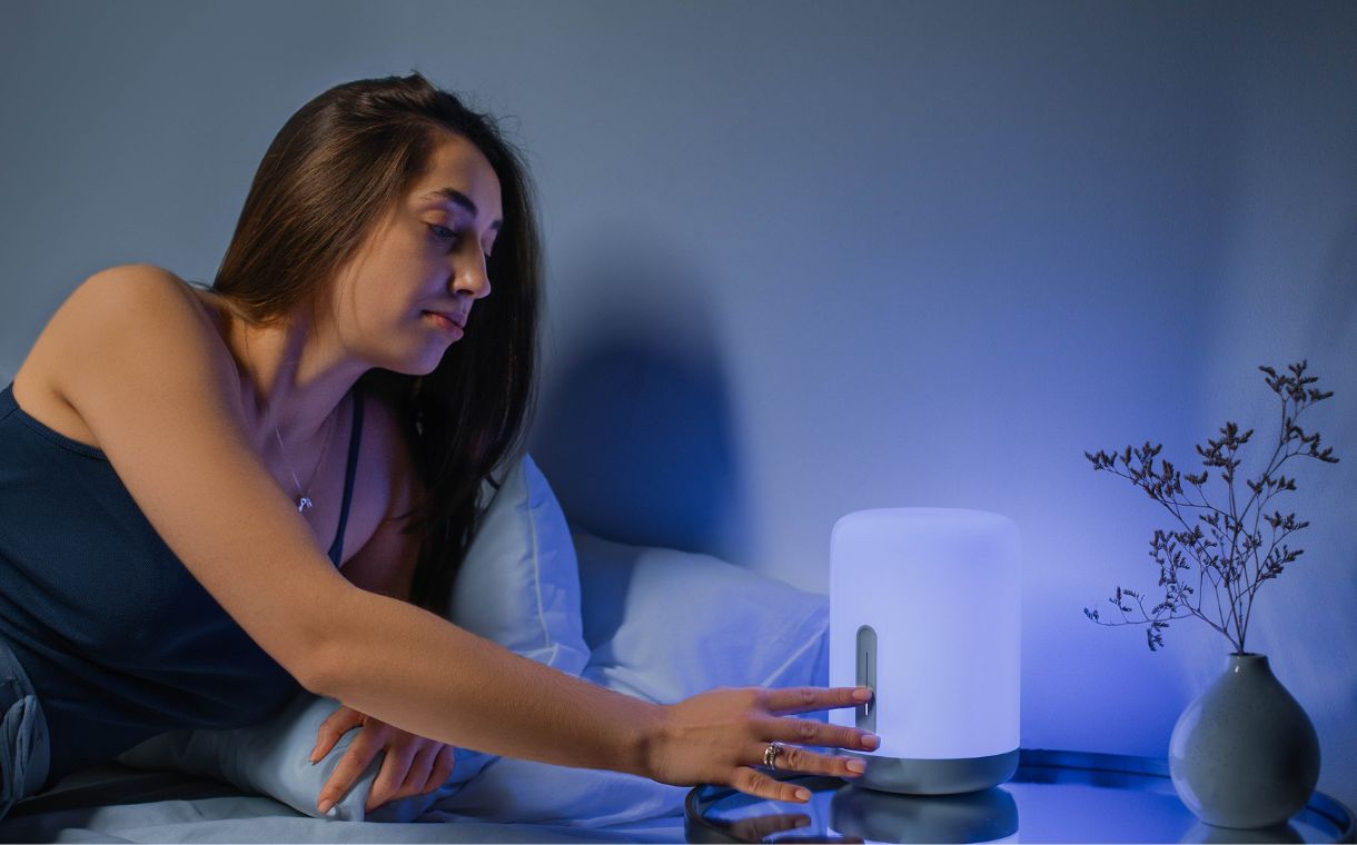 lady turning off bedside lamp