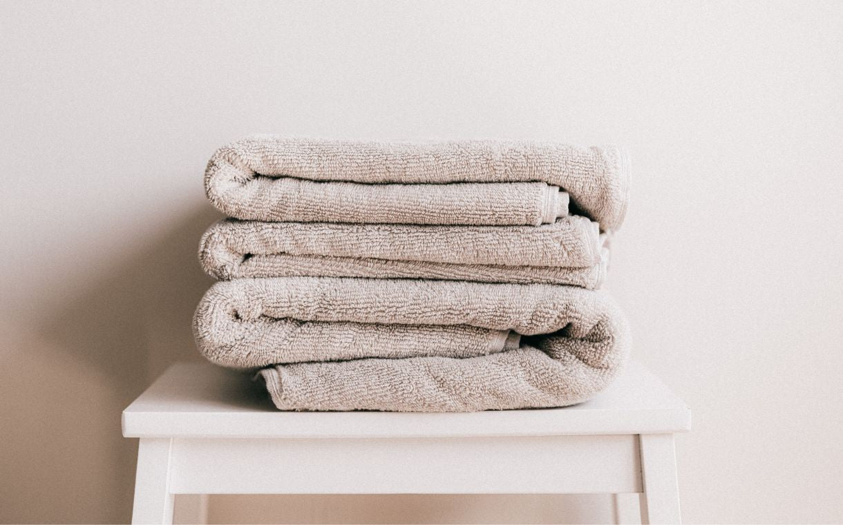 stack of beige towels on white stool