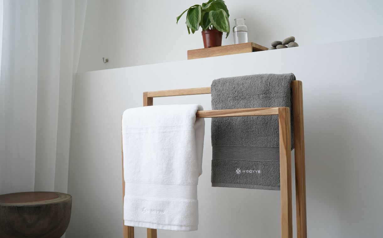 white and grey cotton towels hanging on rack