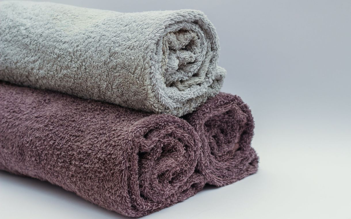 white and maroon folded  towels