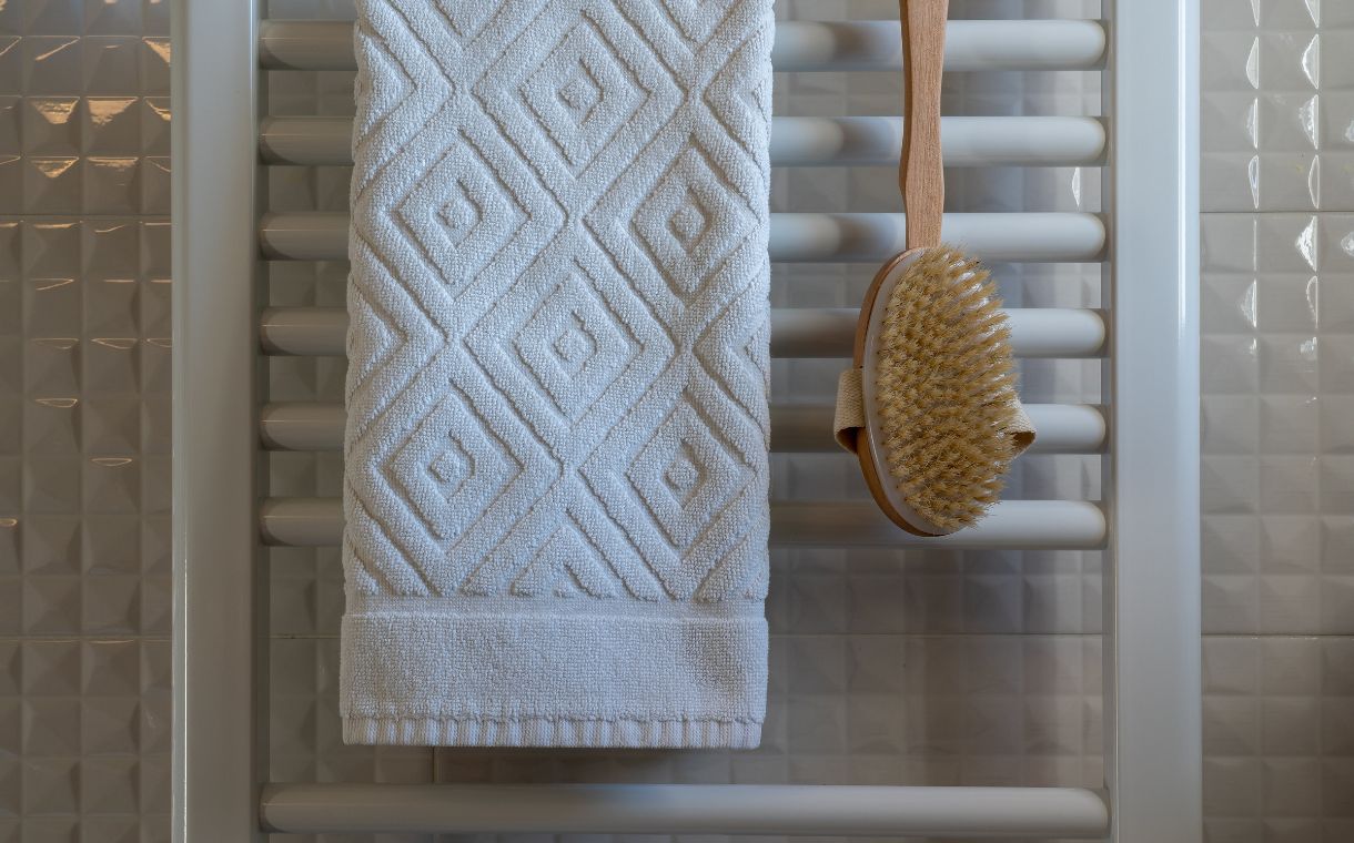 white towel and wooden brush hanging in the bathroom