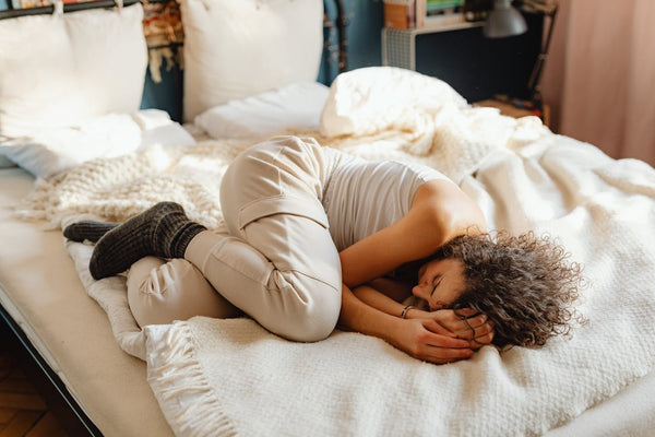 woman in fetal position sleeping without a pillow