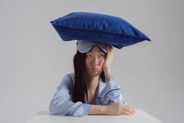 woman in pajama with pillow on her head