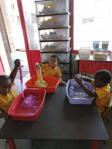 boys playing with magic sand in classroom