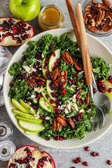 Pomegranate salad is loaded with fresh kale, apple, pomegranate, cranberries, & pecans topped with feta cheese in a tangy maple Dijon vinaigrette.