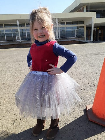 girl standing outside wearing a silver glitter fairy tutu skirt