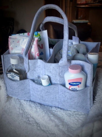 Grey felt nappy organiser with other baby accessories