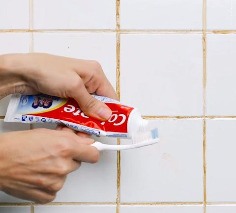 Squeezing toothpaste onto tiles filled with grout