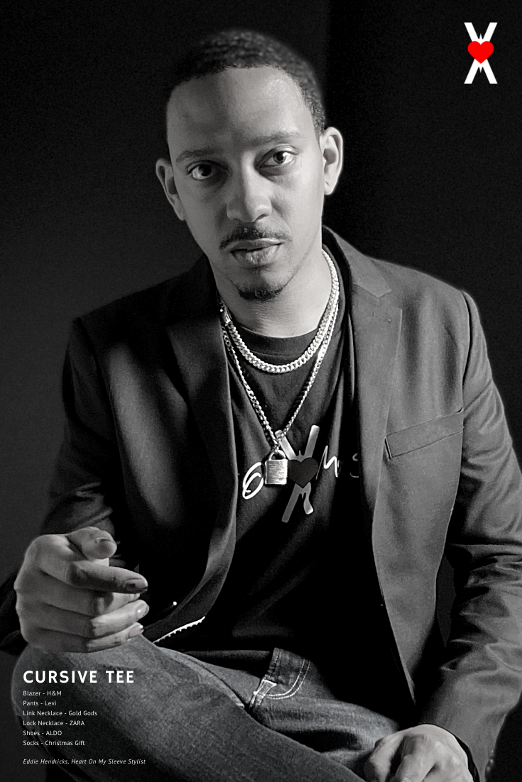 Man wearing black blazer and heart on my sleeve black cursive t-shirt