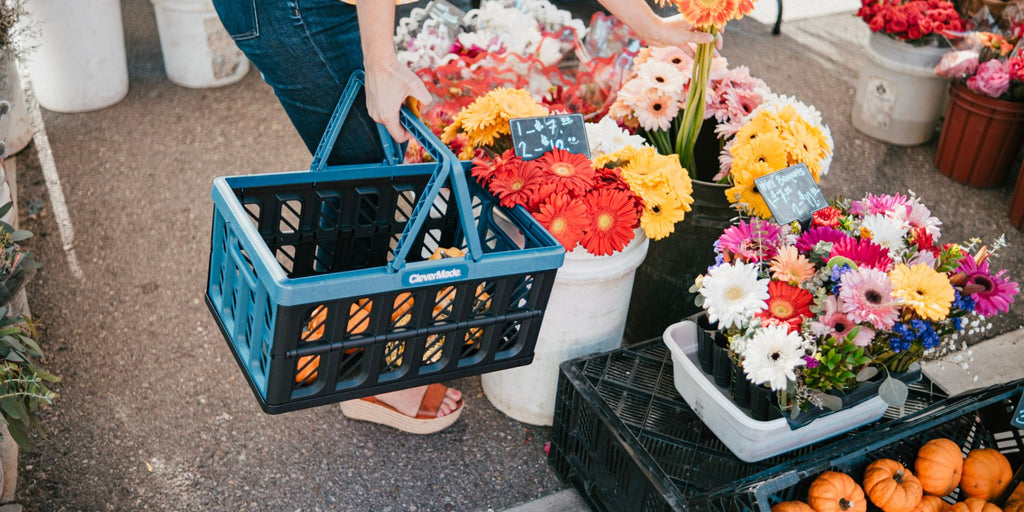 Collapsible shopping basket being used at the farmers market to carry fresh flower bouquets