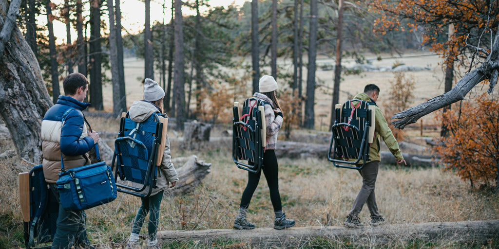 Friends camping with backpack chairs and coolers