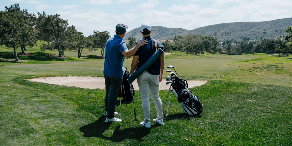 Father and son on golf course and son has a cooler sleeve on his back with 6 cans inside