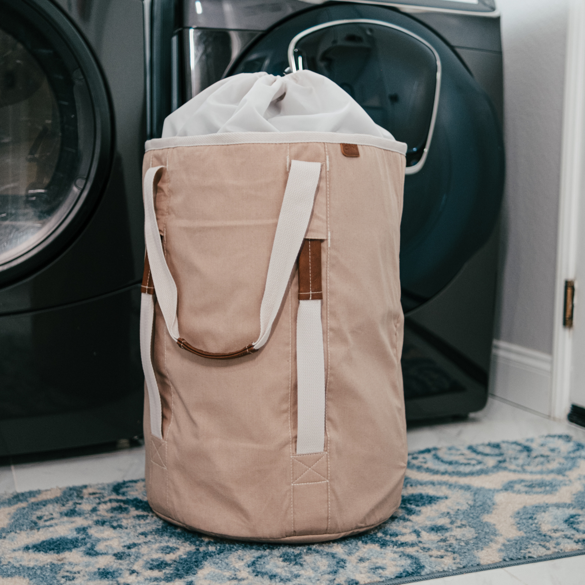 Laundry Duffel LUXE Mocha in front of washer in laundry room