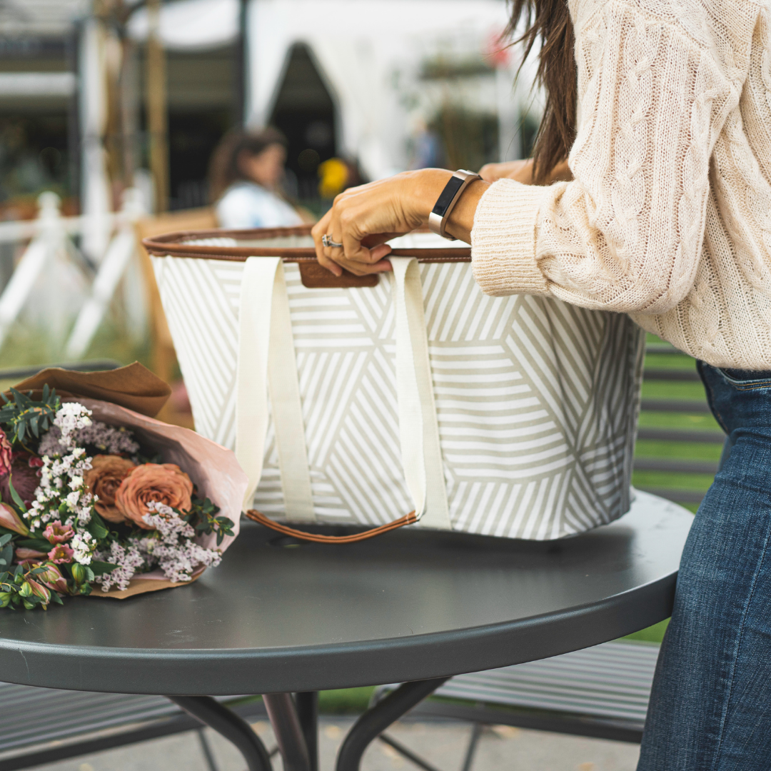 woman packing up her Collapsible LUXE Tote with flowers at the farmers market