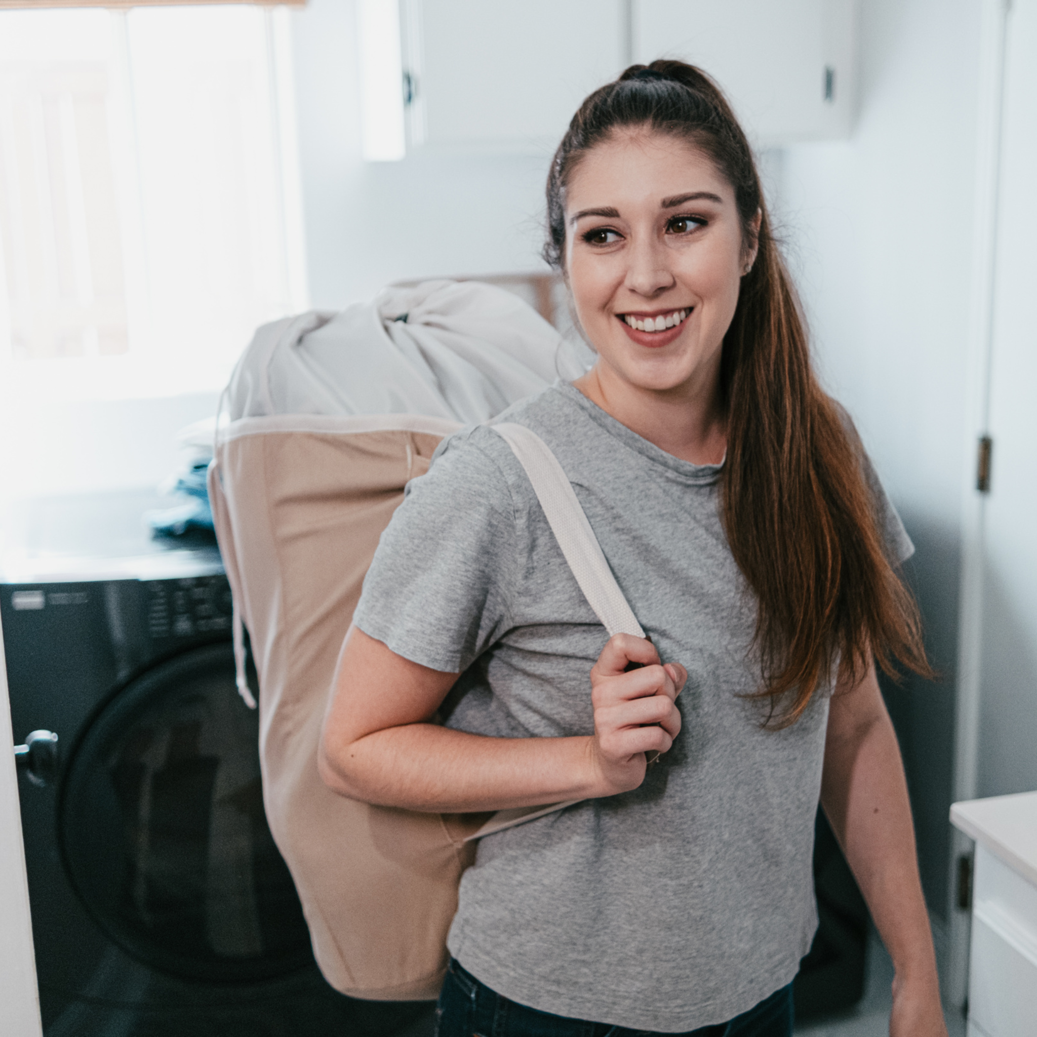 college student carrying laundry in a Laundry Duffel LUXE in mocha