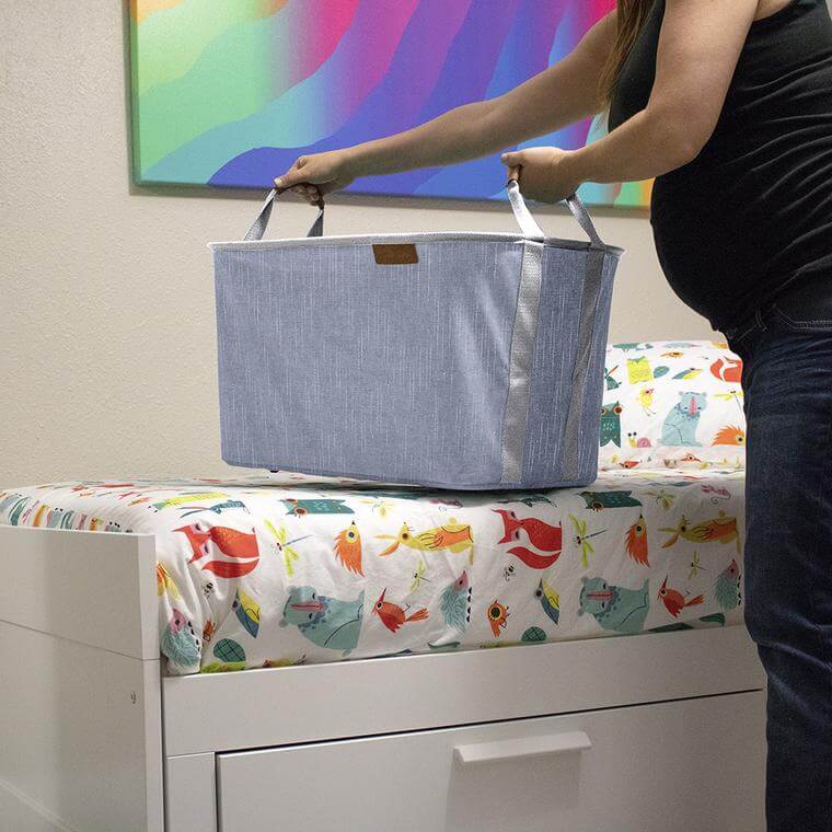 Woman carries a Laundry Basket LUXE from laundry room