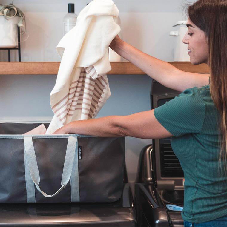 woman pulling out clean clothes from a Laundry Basket Tote