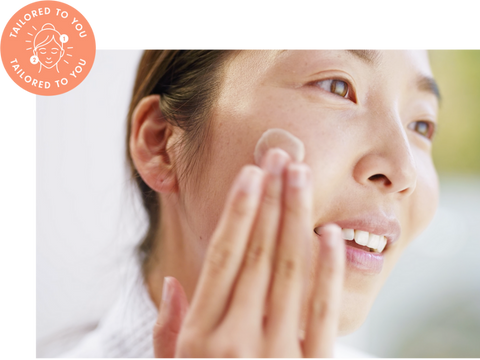 Woman applying Wǒ skincare onto her cheeks.