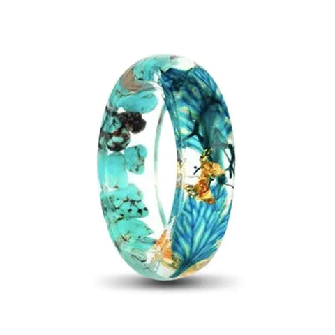 transparent resin ring wit gold foil and blue flowers inlay