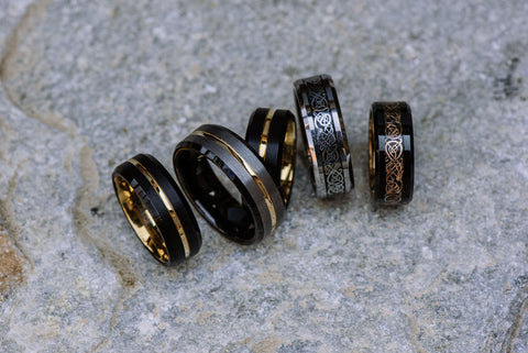 collection of black tungsten carbide rings with gold inlays
