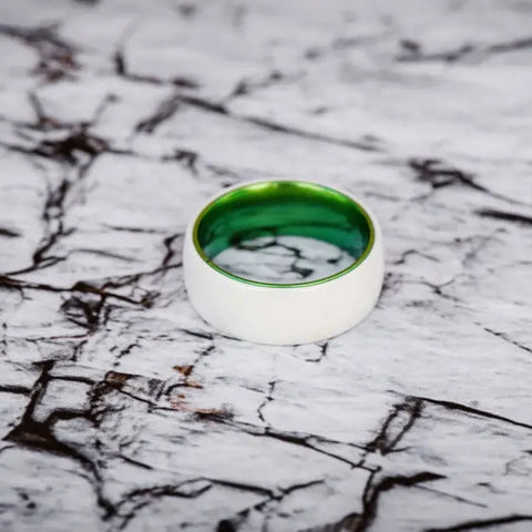 White and Green ceramic ring on marble backdrop
