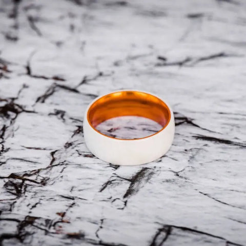 white and orange ceramic ring on marble backdrop