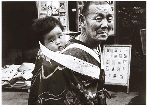 日本の昔、おじいちゃんが赤ちゃんをおんぶする様子