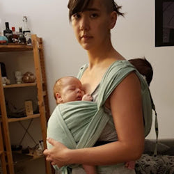 双子の赤ちゃんを抱っこひもで抱っことおんぶする女性