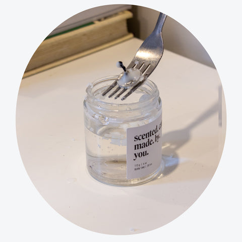 How to clean your used candle jar: remove wick sticker with a fork after the wax has lifted off the bottom with boiling water.