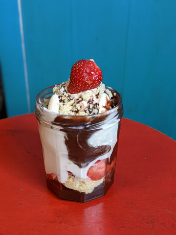 pictured is a strawberry hot fudge sundae in a clear glass jar