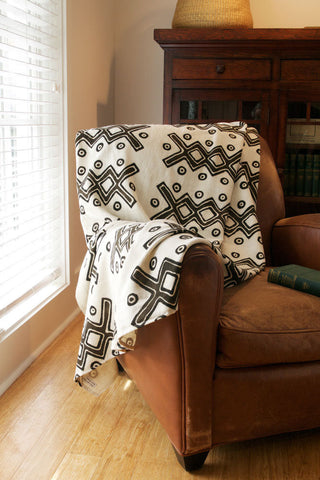 black and cream African print throw blanket on a leather chair