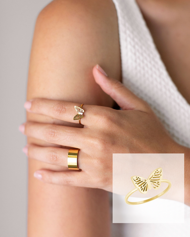 Gold butterfly ring stacked with a thick gold band ring