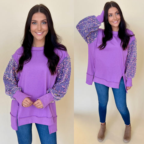 purple oversized sweatshirt with sequin sleeves paired with dark denim skinny jeans and taupe boots