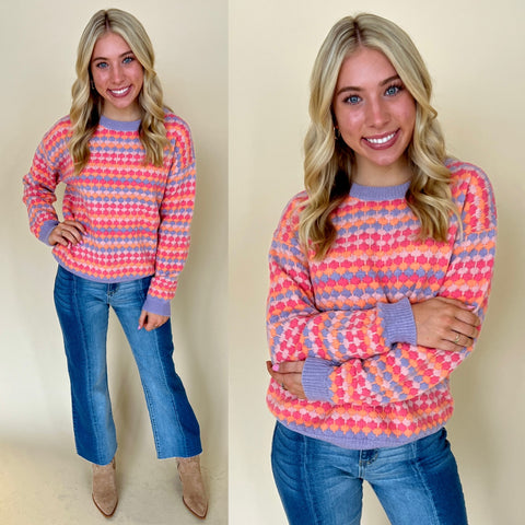 pink orange and purple textured sweater with two tone jeans and boots