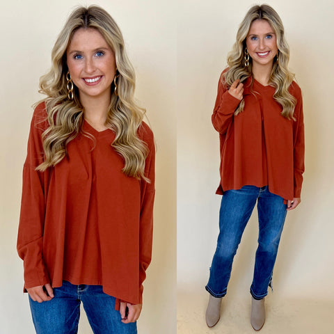 dark rust colored knit top paired with dark denim straight jeans and taupe cowboy boots