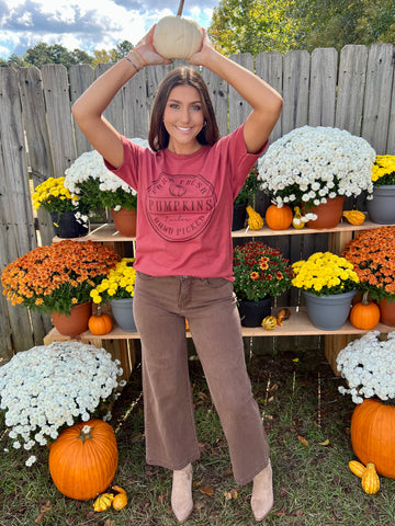 pumpkin theme graphic tee on a basic red tshirt paired with brown wide leg jeans and taupe boots