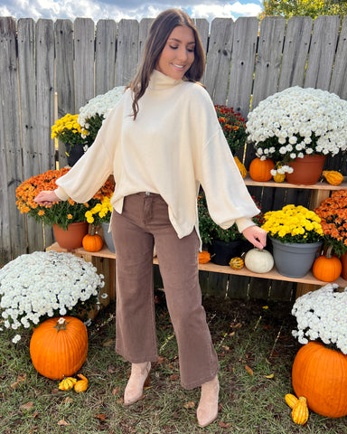 cream turtleneck sweater paired with brown wide leg pants