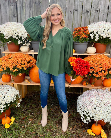 green ruched shoulder button down top with jeans and cowboy boots