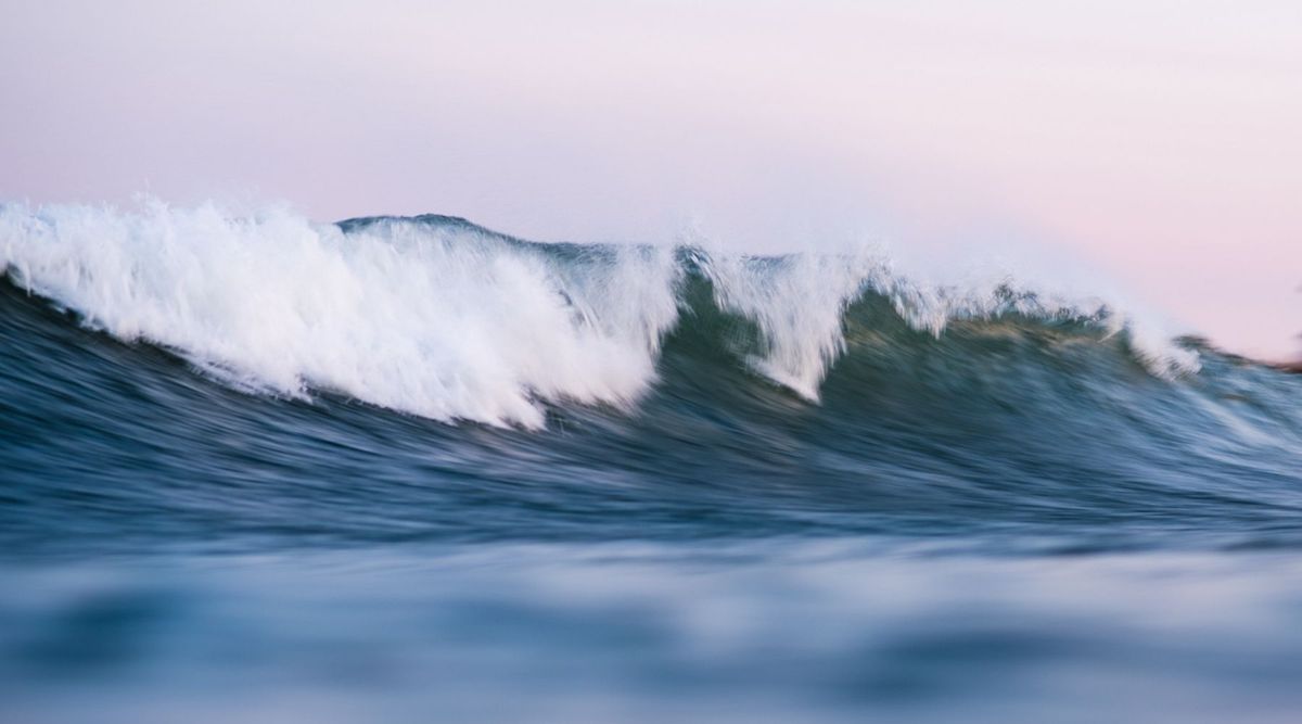 A breaking wave at sunset, taken in the water by female surf photographer Cate Brown