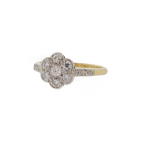 A two-tone Victorian-era ring with a lovely, nature-inspired design. With .30ctw of round diamonds set in platinum with dainty milgrain details, which contrasts beautifully with the 18K yellow gold band.