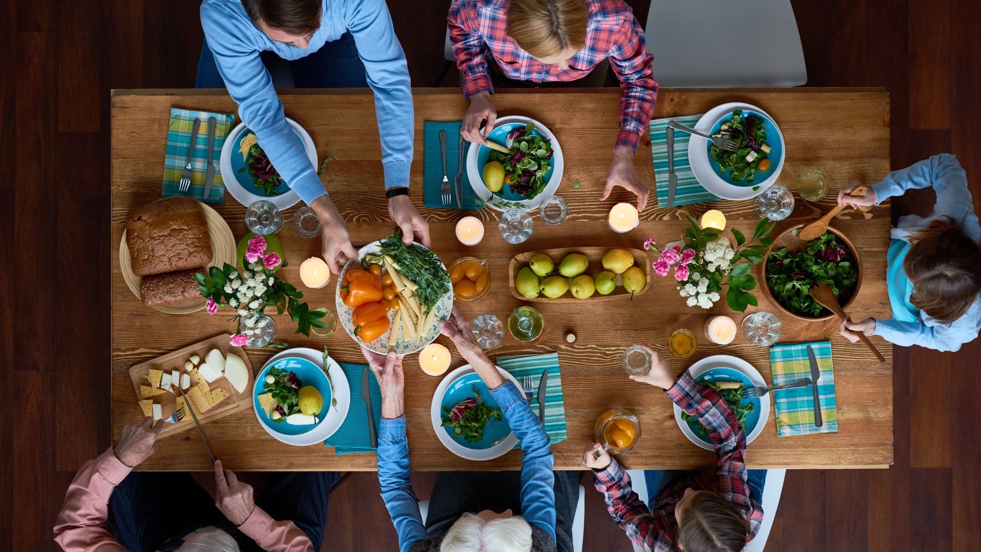 A birds eye shot of a family eating and passing food around the dining table