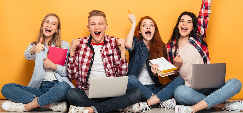 4 excited teenages with computers