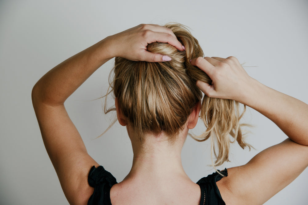 Rear view woman arranging her hair