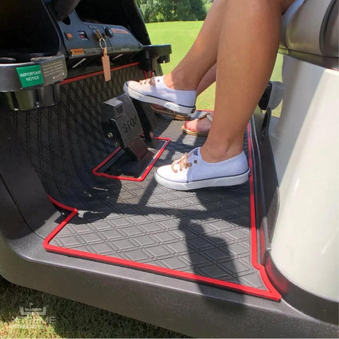 a person driving a golf cart with floor mats