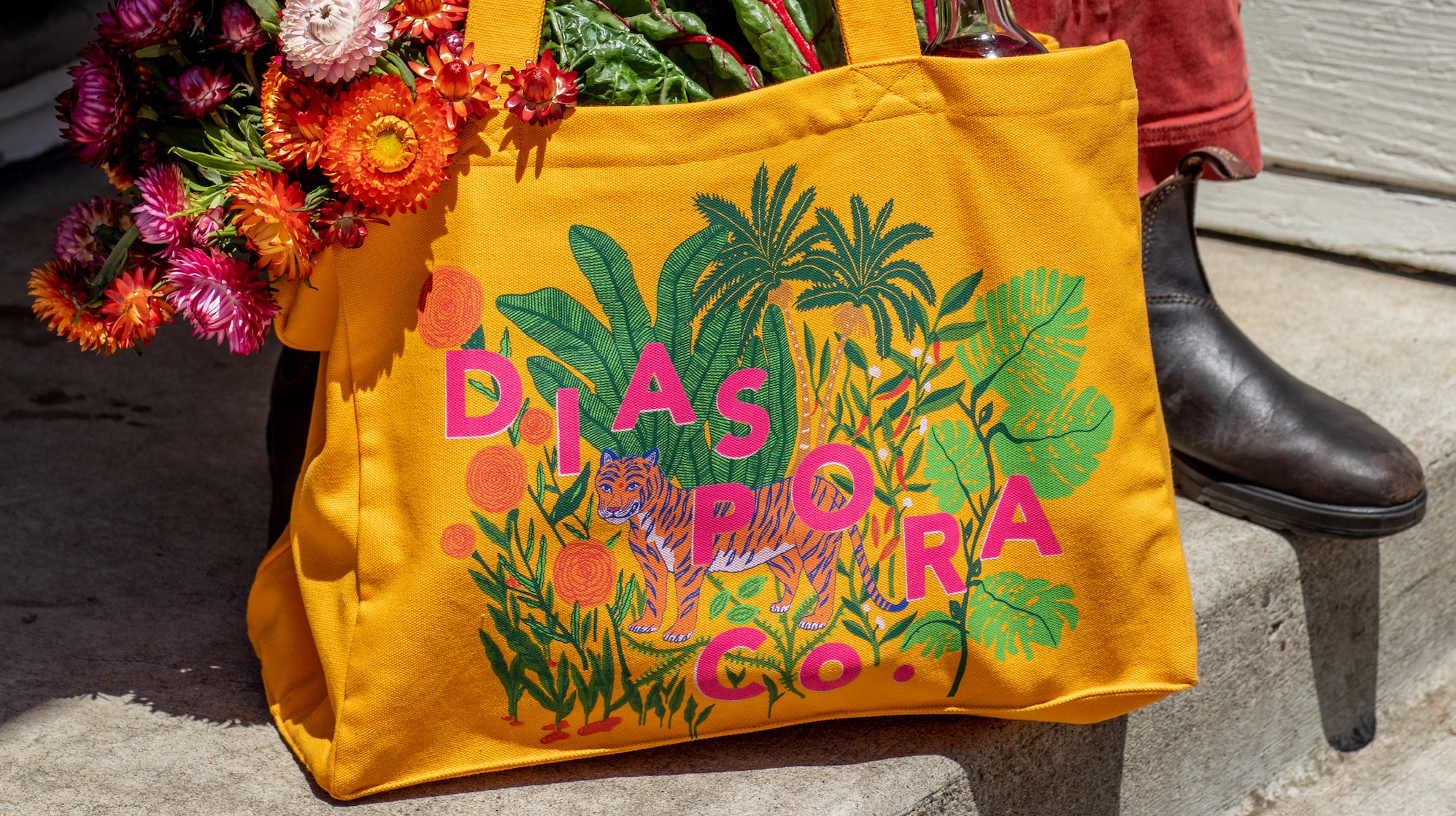 Photo of our market tote bag full of flowers and leafy greens