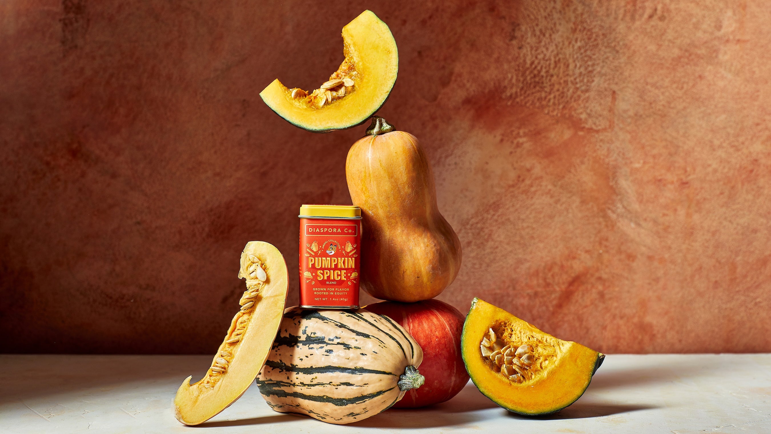 Pumpkin Spice tin styled alongside whole and sliced pumpkins and squash.