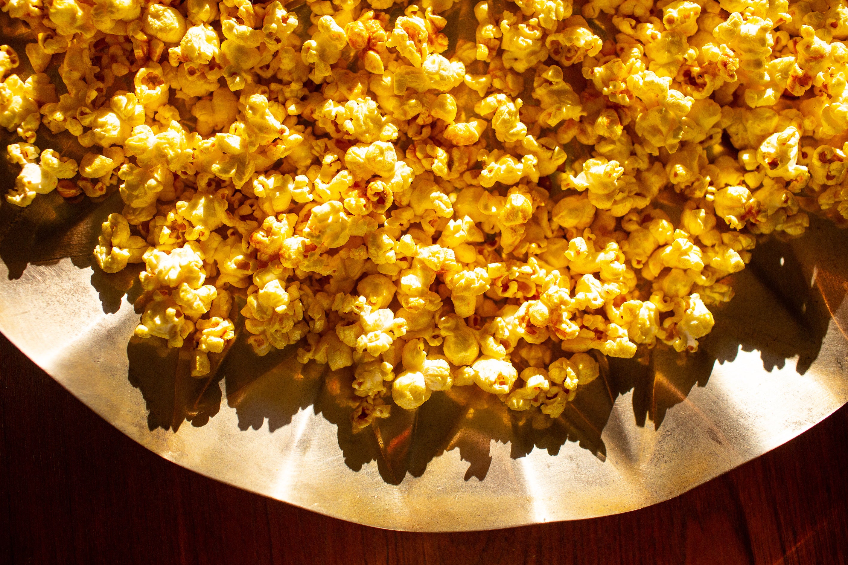 Sunlit popcorn in a bronze metal bowl