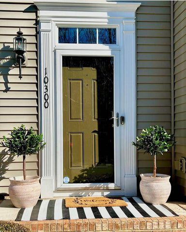 Two small artificial trees from Nearly Natural decorated next to a front door