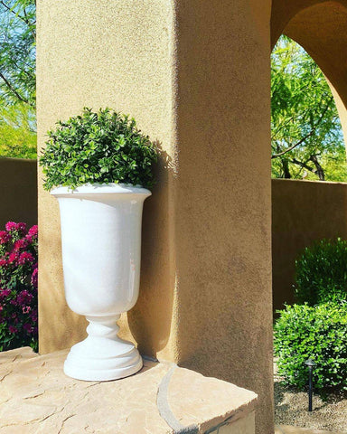 Small bush from Nearly Natural in a tall white urn next to a large column