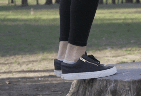 Woman doing calf raises on a tree stump, a good exercise for strengthening the backs of the ankles against arthritis symptoms.